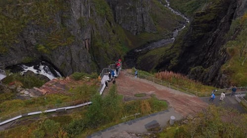 Passe aérienne au-dessus de Voringfossen pendant que les visiteurs se promènent sur les sentiers des falaises