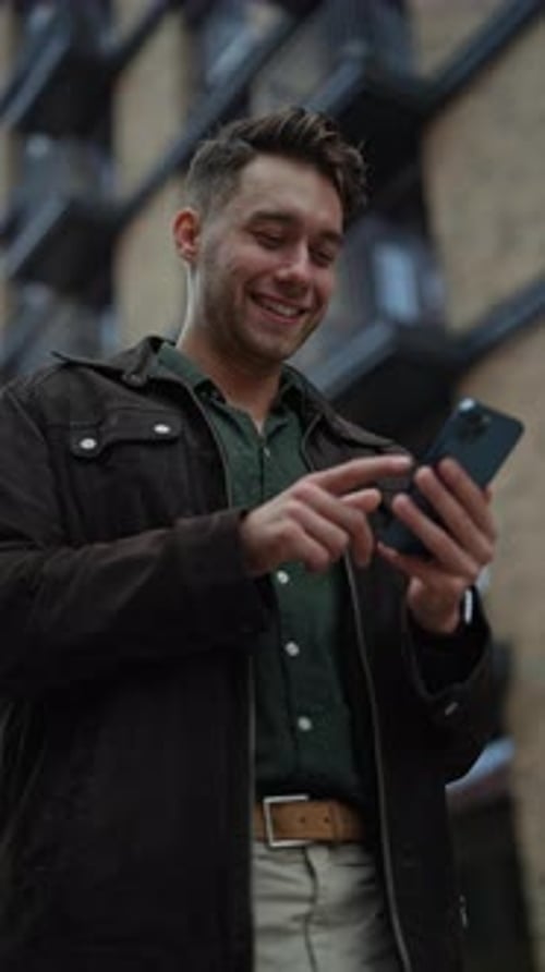 Young Man Using Phone in Urban Setting