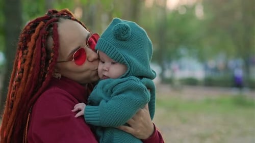 Cute Little Newborn Baby in His Mom's Arms in the Park Autumn Season