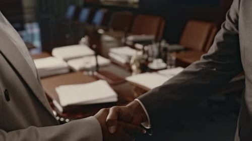 Lawyer Settling Deal with Handshake in Conference Hall