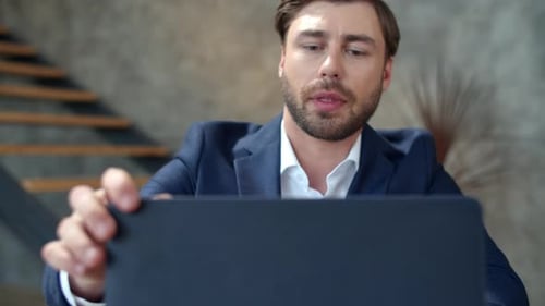 Closeup Handsome Businessman Relaxing at Home Office. Attractive Business Man Closing Laptop