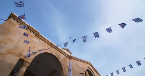 Old Stone Building Decorated with Flags in Sunny City