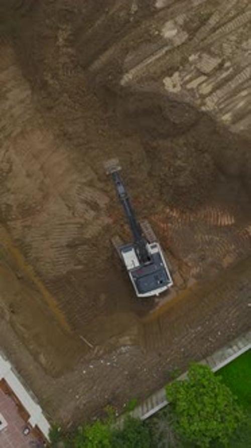 Vídeo vertical de una excavadora excavando en la futura zona de colocación de edificios
