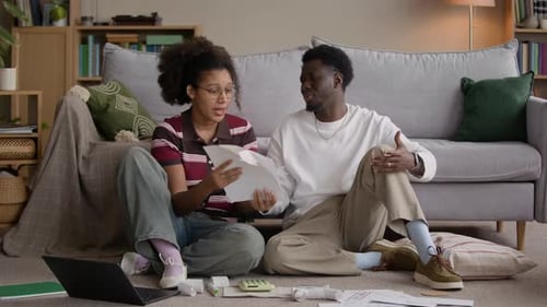Couple Arguing While Reviewing Bills and Household Expenses on Living Room Floor