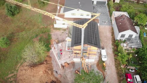 Construction crane carrying windows at construction site