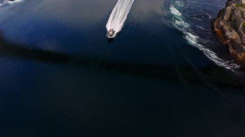 Aerial View of a Boats Driving Through the Saltstraumen Maelstrom in Norway Pan Drone Shot