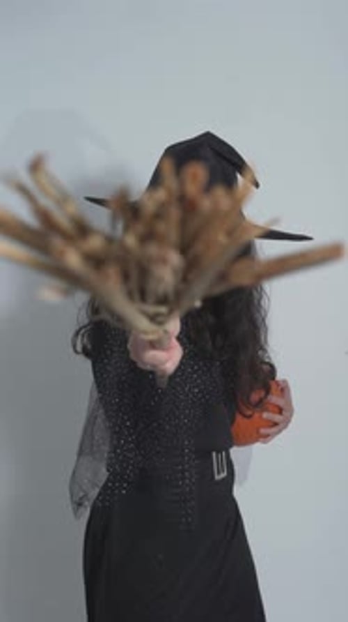 Woman in Witch Costume with Broom and Pumpkin