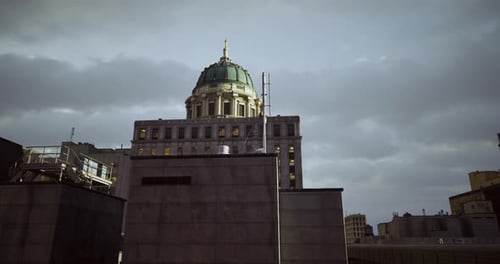 Edificio histórico con cúpula bajo cielos nublados al anochecer en un entorno urbano