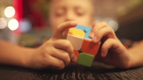 Child's Hands Solving Colorful Puzzle Cube Game