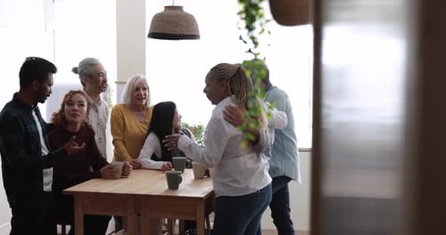 Group of friends talking indoors around a table