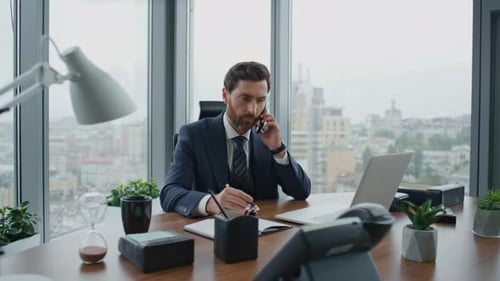 Busy Businessman Making Business Call Checking Information in Laptop Standing Office Desk