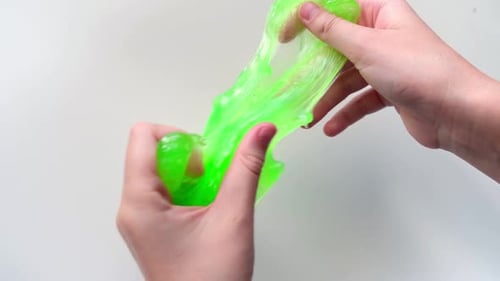 Playing with Textured Slime with Bubbles Stretching the Gooey Substance Female Teen Hand Holding