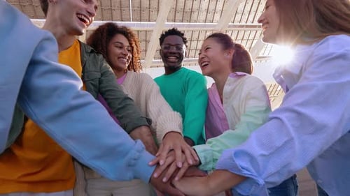 Smiling Friends Stacking Hands in Urban Setting