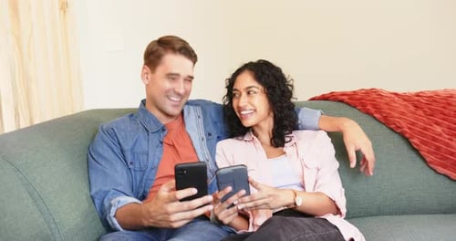 Couple Relaxing Together on Couch Using Mobile Phones