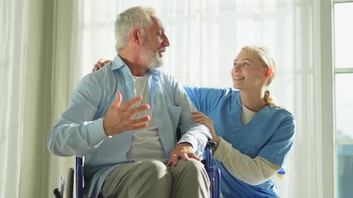 Smiling Caregiver with Senior Man in Wheelchair