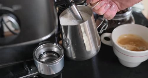 Woman Frothing Milk with a Coffee Machine