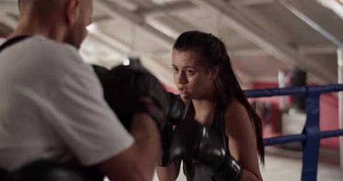 Woman Boxing With Trainer in Indoor Gym