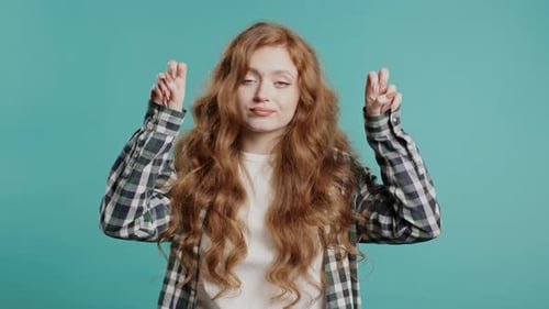 Young Woman Crossing Fingers and Hoping for Good Luck