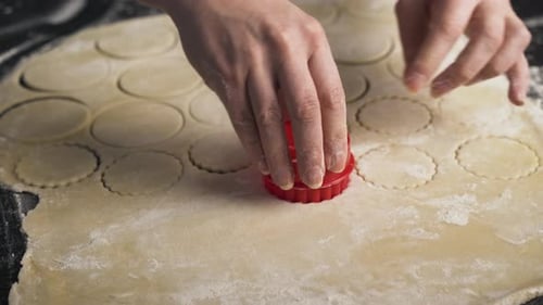 Hands Using Cookie Cutter to Cut Dough
