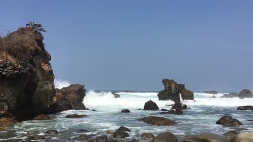 Beautiful landscape of beach with hard Ocean waves hit the rock in Indonesia