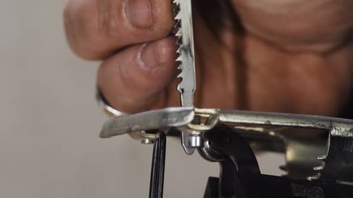 Un artisan du bois insère une lame dans une scie sauteuse en gros plan