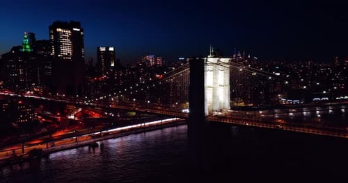 Bright illumination of the Manhattan Bridge at night. Skyline of night New York at backdrop
