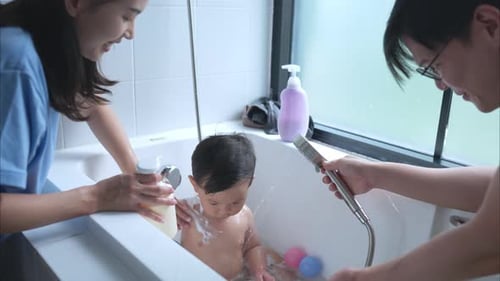 Parents Give Infant a Bath in Bathtub