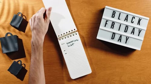 Shopping List on Black Friday with shopping bags