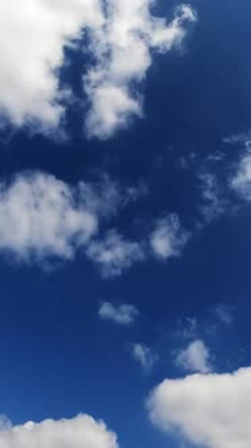 White cotton clouds floating fast in the sky. Blue summer sky with beautiful clouds.