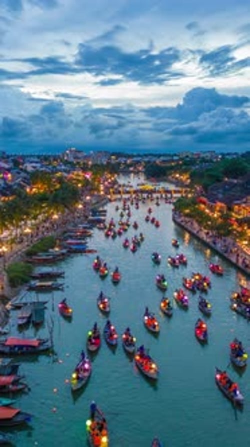 Bateaux en bois traditionnels transportant des hommes et des femmes avec des lanternes colorées lors d'un hyperlapse aérien
