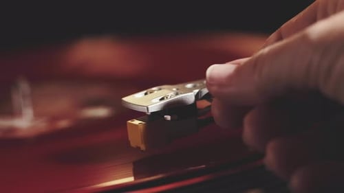 Hand Placing Needle on Red Vinyl Record