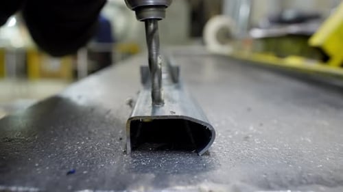 Closeup of a Drill Drilling a Hole in Metal in a Factory