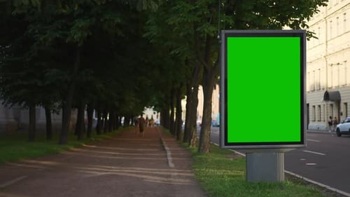 Green Advertising Billboard Stands and Cars Drive Along Road in City Spbd