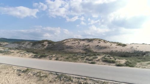 Fast aerial view flying over the beach and sand dunes in Los Canos de Meca Spain