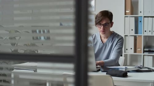 Doctor Working At Desk Examining X-Ray