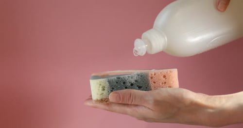 Dish Soap Being Poured onto a Cleaning Sponge