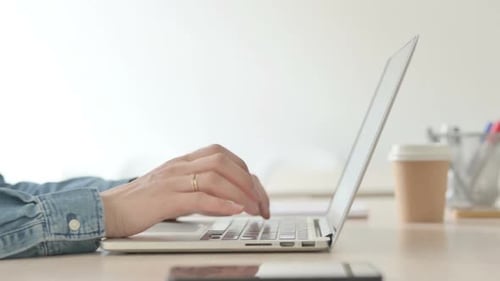 Close Up of Female Hands Typing on Laptop Side View