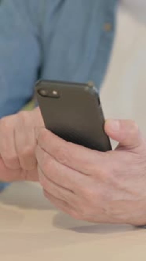 Close up of Old Man Browsing Internet on Smartphone, vertical video