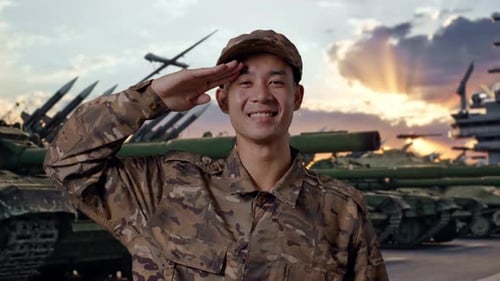 close up of Asian man soldier saluting and smiling With Tank