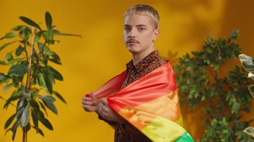 Studio Shot of Confident Man with Moustache in Gay Rainbow Flag Looking at Camera