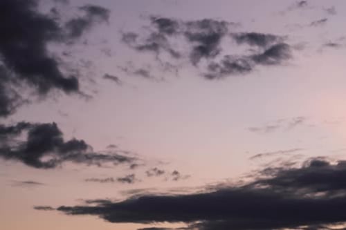 Aerial view of beautiful sky with clouds and sunlight during sunset.