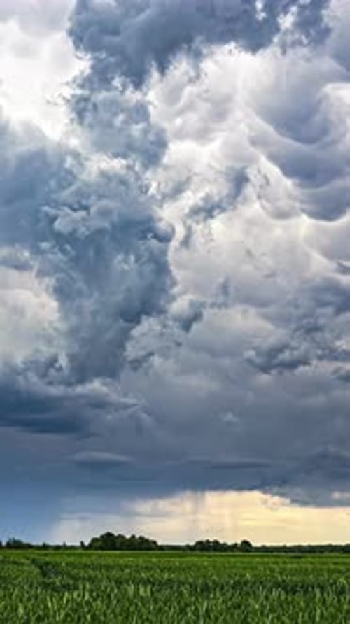 Dramatic Storm Clouds Over Rolling Green Field
