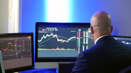 Medium shot of stock broker forex crypto trader man in suit in office analysing charts