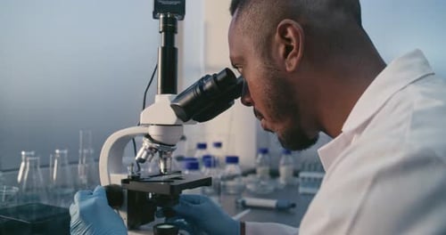 Young Adult Using Microscope in Medical Laboratory