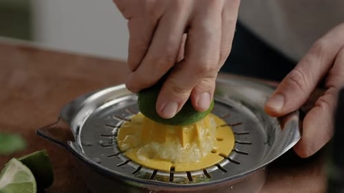 Young male squeezing a lime. Close Up. Slow Motion