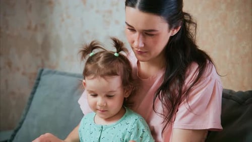 Mom and daughter reading a book together