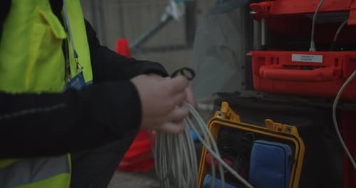 Ausgeschnittene Ansicht einer männlichen Hand beim Verlegen von Datenkabeln zur Vorbereitung des Sportabends