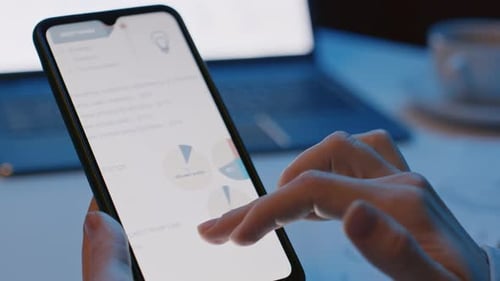 Jemand hält ein Smartphone in der Hand und studiert ein Dokument