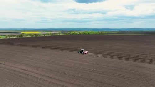 Performant Tractor Working on Agricultural Field in Countryside