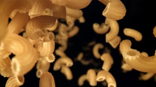 Elbow Macaroni Falling in Slow Motion on Black